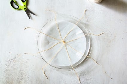 Tied strings in center of parchment-lined pie plate, extended to fall over the rim