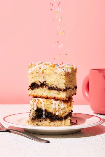 A stack of two slices of Birthday Coffee Cake with sprinkles falling over the top