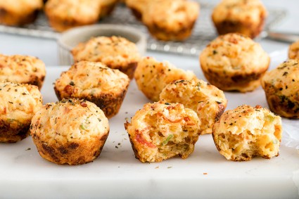 Cheesy pepperoni bites baked in mini muffin pan, some broken in half