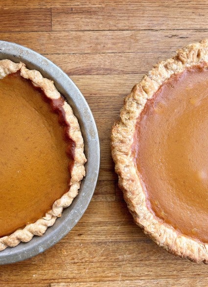 Two baked pumpkin pies side by side; one with crust slumped down sides, one standing up tall.