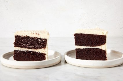 Two chocolate cake slices, one with smears of white frosting on the cake layers, one pristine