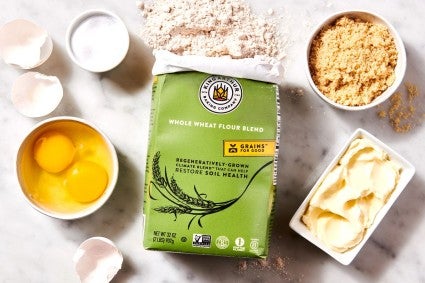 A bag of Climate Blend Flour on a kitchen table surrounded by other baking ingredients