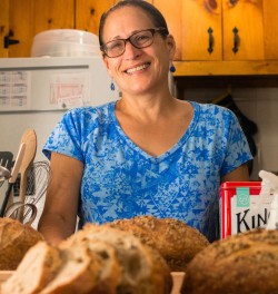 Barbara Alpern in her kitchen with loaves of sourdough bread