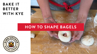 Hands shaping dough into a bagel
